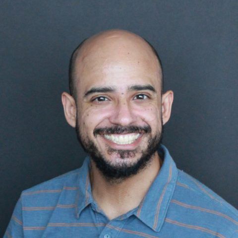 Man smiling at camera from the shoulders up. 