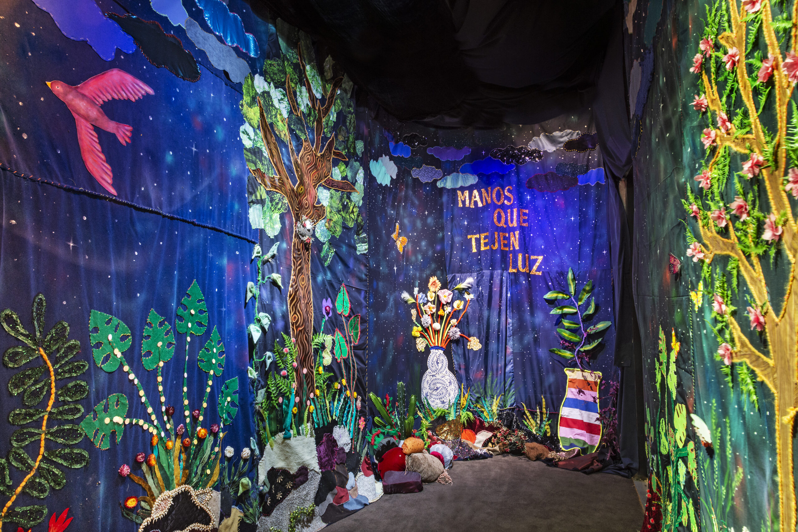 A tapestry of fabric covers the MFTA gallery in lush flora and fauna.