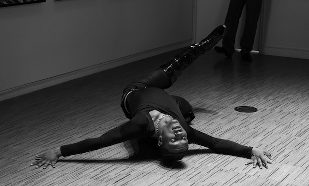 A kiki ballroom dancer poses on the floor after a drop.