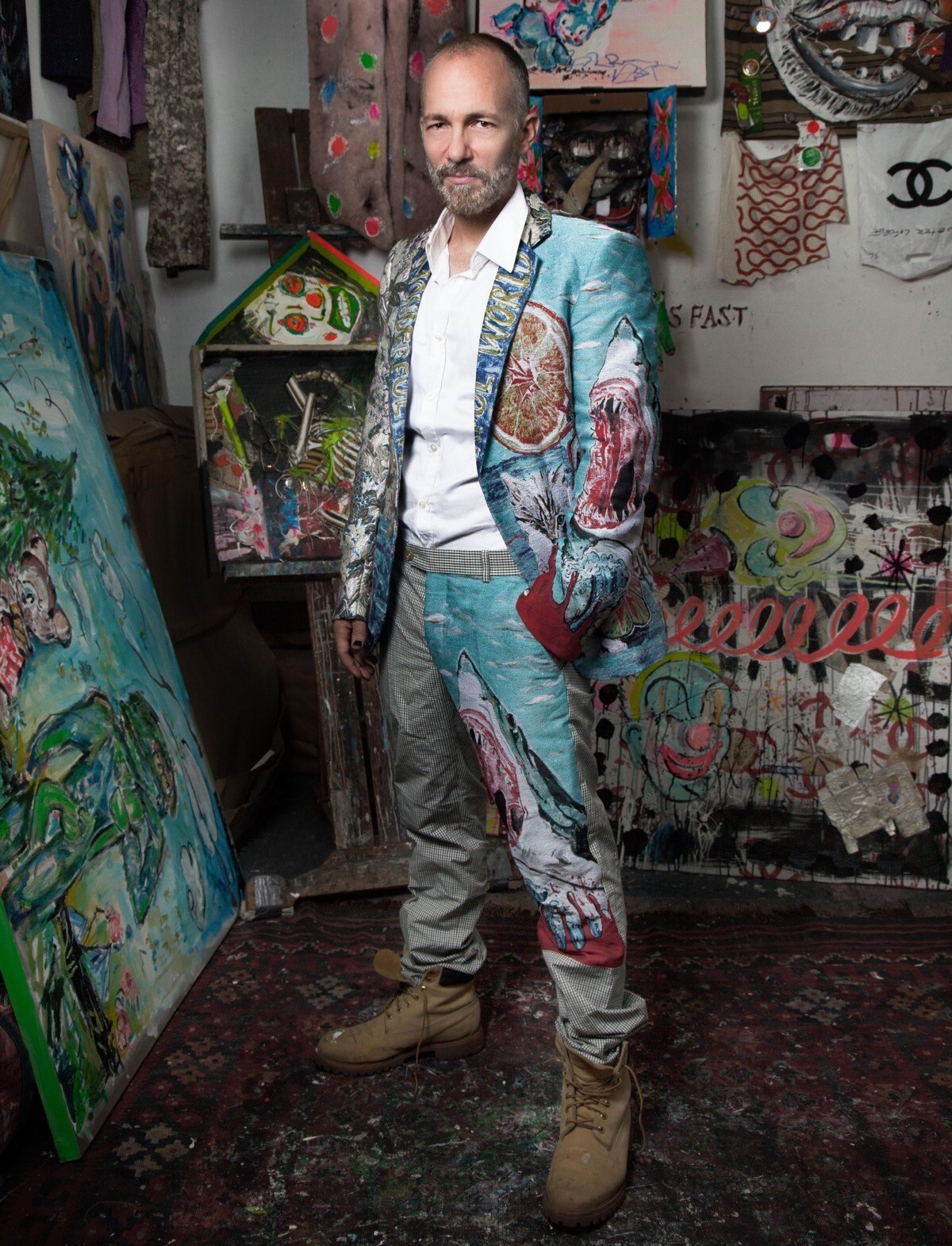 A photo of Scooter LaForge in his studio wearing a colorful suit.