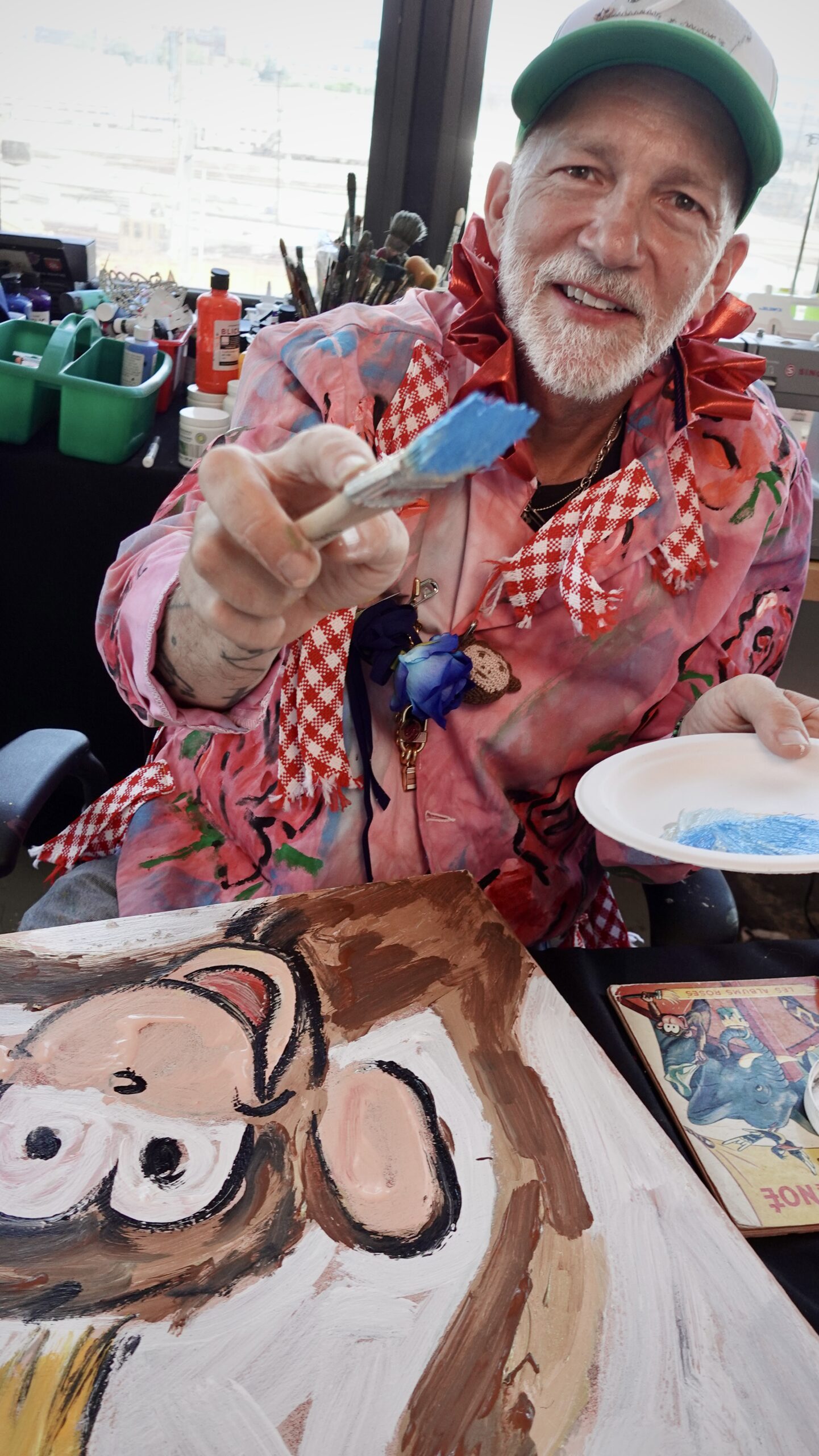 A photo of Scooter LaForge holding up a paint brush with a smile.